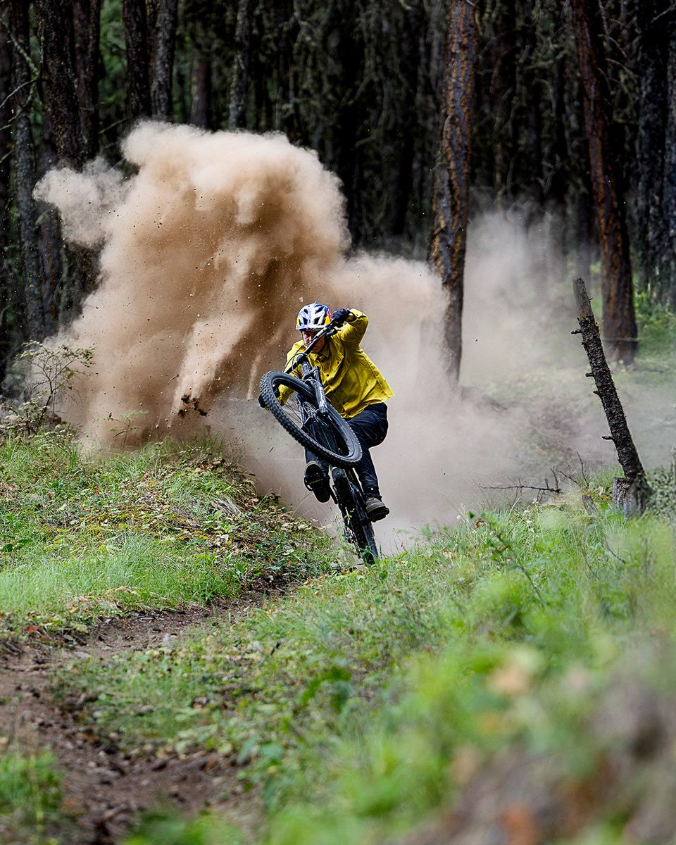 Stisyklist i Troy Lee Designs-utstyr i en støvete sving i skogen