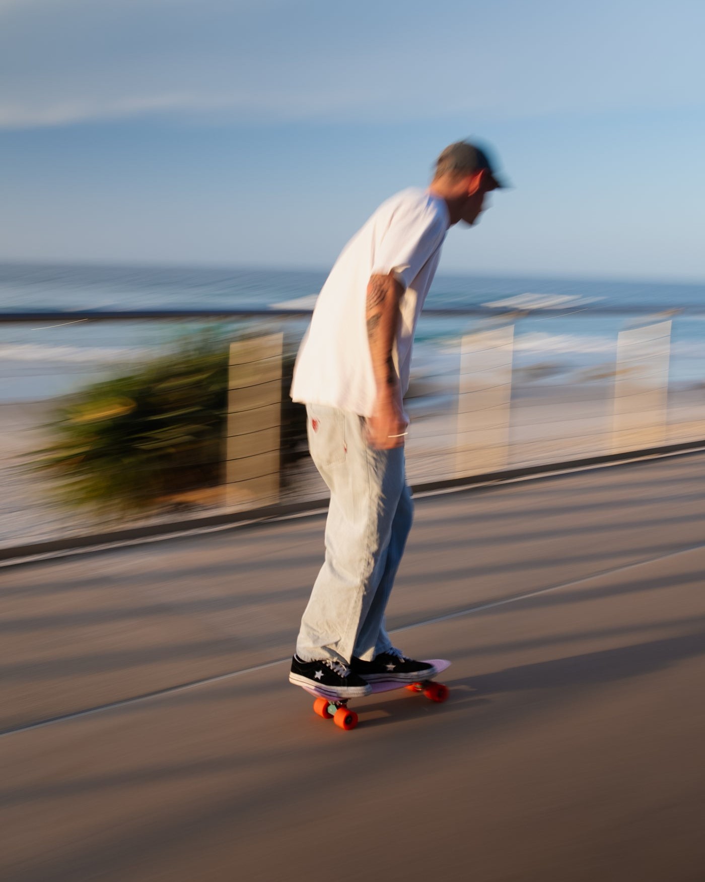 Skater på Penny-brett langs en strandpromenade